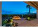 Inviting backyard with a stone patio and rock-ringed fire pit under the evening sky at 1617 E Copper Holw, Queen Creek, AZ 85140
