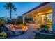 Backyard with stone patio, fire pit, and views of the covered living and dining spaces at 1617 E Copper Holw, Queen Creek, AZ 85140
