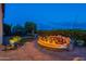 Charming backyard with patio, fire pit, and an outdoor dining set at dusk at 1617 E Copper Holw, Queen Creek, AZ 85140
