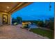 A paver patio features a built-in fire pit, manicured landscaping and desert views at 1617 E Copper Holw, Queen Creek, AZ 85140