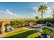 A paver patio features a built-in fire pit, manicured landscaping and desert views at 1617 E Copper Holw, Queen Creek, AZ 85140