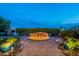 Cozy backyard with stone patio featuring a charming rock fire pit with decorative potted plants at 1617 E Copper Holw, Queen Creek, AZ 85140