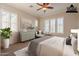 Bright staged bedroom with a ceiling fan, shutters, and contemporary decor at 1617 E Copper Holw, Queen Creek, AZ 85140
