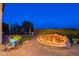 Charming backyard featuring a cozy fire pit and stone patio, perfect for relaxing evenings and outdoor gatherings at 1617 E Copper Holw, Queen Creek, AZ 85140