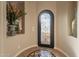 Elegant foyer features a decorative front door, stylish tile flooring, and a niche with floral arrangement at 1617 E Copper Holw, Queen Creek, AZ 85140