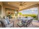 Relaxing covered patio with comfortable seating, offering a peaceful retreat and picturesque views of the manicured backyard at 1617 E Copper Holw, Queen Creek, AZ 85140