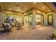 Inviting covered patio with ample seating and multiple doors leading into the home at 1617 E Copper Holw, Queen Creek, AZ 85140