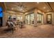 Inviting covered patio with ample seating and multiple doors leading into the home at 1617 E Copper Holw, Queen Creek, AZ 85140