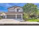 Inviting two-story home featuring a three-car garage and lush landscaping at 1697 E Linda Ln, Gilbert, AZ 85234