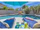Relaxing backyard pool with lounge chairs, waterfall feature, drinks, and desert landscaping at 1697 E Linda Ln, Gilbert, AZ 85234