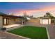 Backyard with artificial grass, gravel landscaping, and a covered patio, offering a low-maintenance outdoor space at 1801 E Berridge Ln, Phoenix, AZ 85016