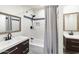 Well-lit bathroom features a shower-over-tub and dual vanity with wood cabinets at 1801 E Berridge Ln, Phoenix, AZ 85016