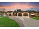 View of the home with a long driveway leading to a spacious two-car garage and front entryway at 1801 E Berridge Ln, Phoenix, AZ 85016