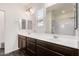 Bathroom with dual sinks, dark wood cabinets, white countertops, and a large mirror at 19847 W Monroe St, Buckeye, AZ 85326