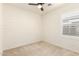 Carpeted bedroom offers neutral decor, a ceiling fan, a window with shutters, and electrical outlets at 19847 W Monroe St, Buckeye, AZ 85326