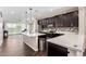 Modern kitchen features dark cabinetry, stainless steel appliances, tiled backsplash, and a breakfast bar at 19847 W Monroe St, Buckeye, AZ 85326