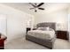 Well-lit main bedroom features a large tufted headboard, ceiling fan, and ensuite bathroom at 19847 W Monroe St, Buckeye, AZ 85326