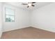 A bedroom view with carpet, ceiling fan, and a window providing natural light at 2046 E Paradise Ln, Phoenix, AZ 85022