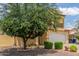 Home's front exterior showing desert landscaping, a tree, and two-car garage at 2046 E Paradise Ln, Phoenix, AZ 85022