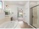 Luxurious bathroom with soaking tub, shower, double sinks, and balcony access at 2046 E Paradise Ln, Phoenix, AZ 85022