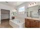 Luxurious bathroom with soaking tub, double sinks, and plenty of natural light at 2046 E Paradise Ln, Phoenix, AZ 85022
