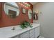 Bathroom featuring double sinks, decorative mirrors, vanity cabinet and accent wall at 205 N 74Th St # 227, Mesa, AZ 85207