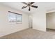 Neutral bedroom featuring a window, ceiling fan, carpet, and doorway to another room at 2286 E Mohave Ln, Apache Junction, AZ 85119