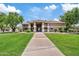 Community clubhouse featuring a terracotta tile roof, stucco walls, and lush landscaping at 2286 E Mohave Ln, Apache Junction, AZ 85119