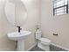 Stylish powder room with a pedestal sink, decorative mirror, and patterned tile flooring at 23010 E Pummelos Rd, Queen Creek, AZ 85142