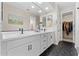 Modern bathroom with a double sink vanity, black hardware, a walk-in closet, and stylish geometric floor tiles at 23010 E Pummelos Rd, Queen Creek, AZ 85142