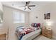 Fun ' bedroom with twin bed featuring superhero bedding, natural light, and a ceiling fan at 23010 E Pummelos Rd, Queen Creek, AZ 85142