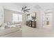 Spacious bonus room with plush sofa, large TV, stylish media cabinet and modern ceiling fan at 23010 E Pummelos Rd, Queen Creek, AZ 85142
