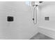 Sleek, modern walk-in shower featuring white subway tile, dark fixtures, and a built-in bench for added comfort at 23010 E Pummelos Rd, Queen Creek, AZ 85142