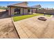Large backyard with stone patio, artificial turf, covered patio, fire pit, and block fence at 24811 W Wayland Dr, Buckeye, AZ 85326