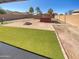 Private backyard featuring artificial grass, a fire pit, and ample space for outdoor activities at 24811 W Wayland Dr, Buckeye, AZ 85326