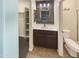 Bright bathroom with decorative mirror, updated vanity, tile flooring, and separate toilet room at 24811 W Wayland Dr, Buckeye, AZ 85326