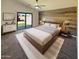 Stylish main bedroom featuring a modern accent wall, ceiling fan, and sliding glass door to backyard at 24811 W Wayland Dr, Buckeye, AZ 85326