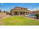 Backyard view with green lawn, desert landscaping and refreshing pool at 26080 N 73Rd Ln, Peoria, AZ 85383