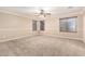 Spacious bedroom with neutral tones, a ceiling fan and three windows to the outside at 26080 N 73Rd Ln, Peoria, AZ 85383