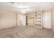 Large bedroom with carpet, ceiling fan, built-in shelving, and ensuite bathroom at 26080 N 73Rd Ln, Peoria, AZ 85383