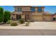 Two-story home featuring stone accents, a three-car garage, and a well-maintained front yard at 26080 N 73Rd Ln, Peoria, AZ 85383