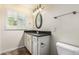 Bathroom featuring granite countertop, white cabinets, oval mirror, and shuttered window at 2807 N 8Th Ave, Phoenix, AZ 85007