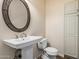 Bathroom featuring pedestal sink, oval mirror, and nearby toilet and storage cabinet at 2807 N 8Th Ave, Phoenix, AZ 85007
