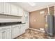 Laundry room features white cabinets, countertop, water heater, and door to the outside at 2807 N 8Th Ave, Phoenix, AZ 85007