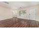 Bright living room featuring wood flooring, plantation shutters, and a view into another room at 2807 N 8Th Ave, Phoenix, AZ 85007