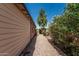 Gravel side yard leading to backyard with privacy fence, mature trees and flowering shrubs at 2807 N 8Th Ave, Phoenix, AZ 85007