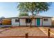 Charming single-story home featuring desert landscaping, a carport, and a vibrant turquoise front door at 3012 W Butler Dr, Phoenix, AZ 85051