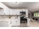 Updated kitchen boasts stainless steel appliances, white cabinetry, and sleek countertops at 3012 W Butler Dr, Phoenix, AZ 85051