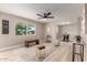 Bright living room featuring sleek ceiling fan, neutral walls, stylish furnishings, and a large window overlooking yard at 3012 W Butler Dr, Phoenix, AZ 85051