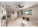 Bright living room featuring sleek ceiling fan, neutral walls, stylish furnishings, and light wood-look flooring at 3012 W Butler Dr, Phoenix, AZ 85051